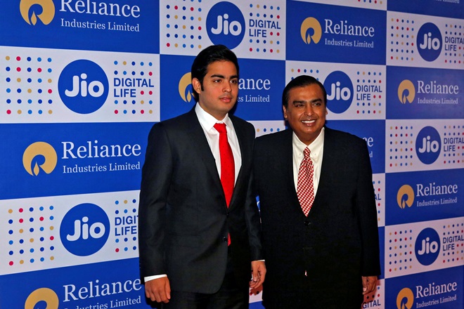 Mukesh Ambani, chairman of Reliance Industries Ltd, poses with his son Akash in Mumbai