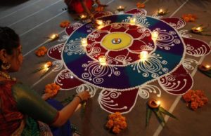 Hindu women arrange oil lamps and flowers around a "Rangoli", a traditional pattern made from coloured powders, during the celebrations ahead of the Hindu festival of Diwali in Ahmedabad November 1, 2013. REUTERS/Amit Dave/Files