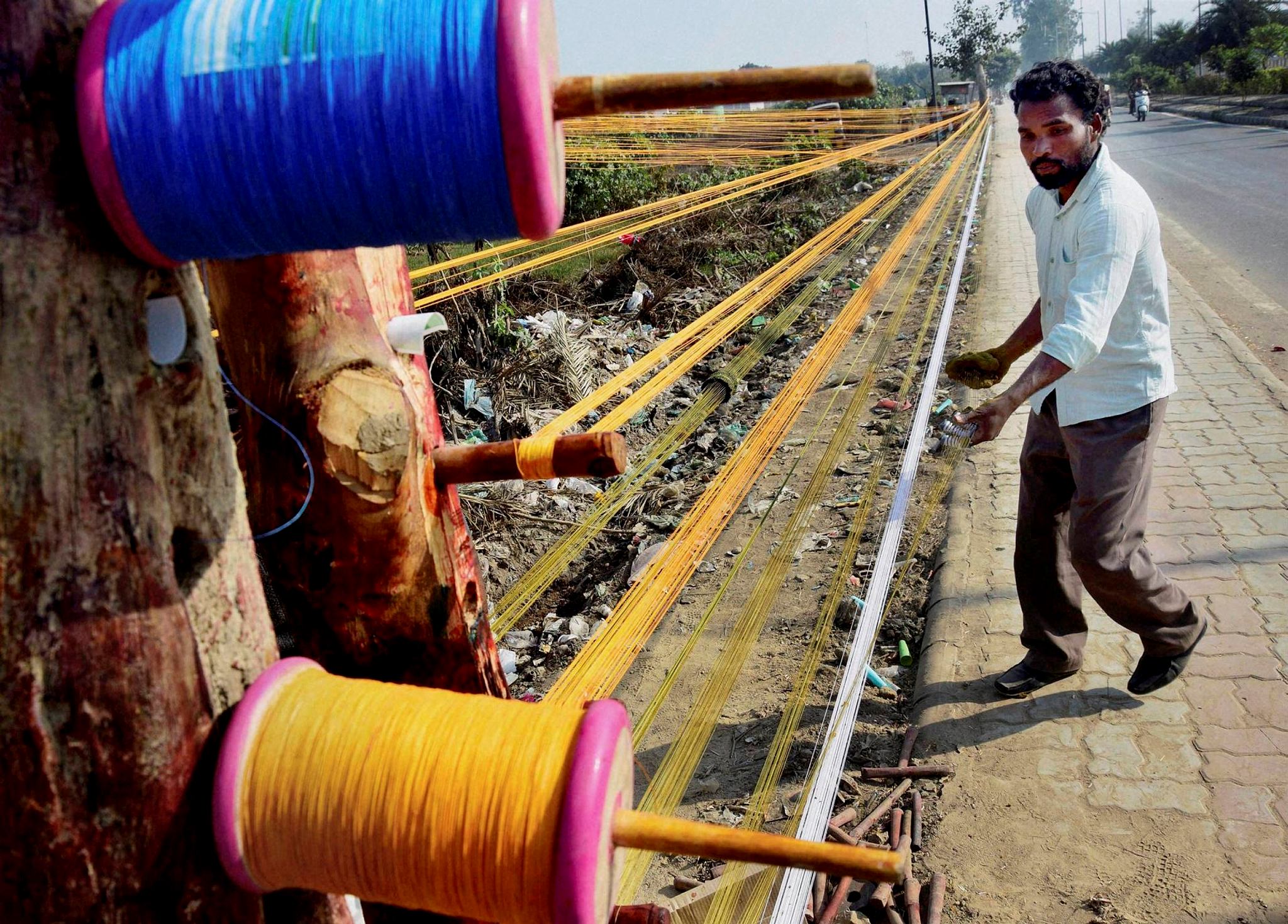 A worker prepares coloured kite strings ahead of the Lohri festival in Amritsar on Tuesday. (PTI)