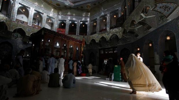 FILE PHOTO: A woman clad in burqa walks in the hallway of the tomb of Sufi saint Syed Usman Marwandi, also known as Lal Shahbaz Qalandar, in Sehwan Sharif, in Pakistan's southern Sindh province. (Reuters)