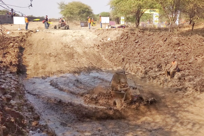 A participant of mBAJA SAEINDIA 2018 splashing through the mud.