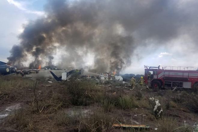 Note: This image is from Mexico's northern state of Durango, July 31, 2018, in which firefighters douse a fire as smoke billows above the site where an Aeromexico-operated Embraer passenger jet which crashed Proteccion Civil Durango/via REUTERS